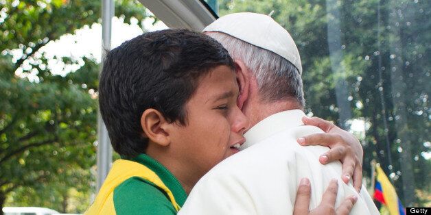 Pope Francis hugs a boy at Quinta da Boa Vista Park in Rio de Janeiro, Brazil, on July 26, 2013. Pope Francis returned to Rome late Sunday after leading a giant beach mass in Brazil for three million pilgrims, ending his historic trip to reignite Catholic passion with pleas for a humbler Church. AFP PHOTO/LUCA ZENNARO/POOL (Photo credit should read LUCA ZENNARO/AFP/Getty Images)