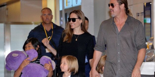 US film stars Brad Pitt (R) and Angelina Jolie (back C), accompanied by their children, arrive at Haneda International Airport in Tokyo on July 28, 2013. Pitt is now here for the promotion of his latest movie 'World War Z'. AFP PHOTO / Yoshikazu TSUNO (Photo credit should read YOSHIKAZU TSUNO/AFP/Getty Images)