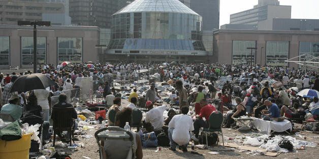 New Orleans, UNITED STATES: People are shown at the Superdome in New Orleans, Louisiana in the aftermath of Hurricane Katrina 02 September 2005.This onetime glittering jazz capital was an armed camp 02 September, as troops backed by armored personnel carriers and helicopters poured in to take on looters and thugs running rampant since Hurricane Katrina struck. The bumper-to-bumper convoys of emergency vehicles rumbling into New Orleans were a welcome sight to thousands of desperate survivors living in terror and scrounging for food and water for four nightmarish days. AFP PHOTO / James NIELSEN (Photo credit should read JAMES NIELSEN/AFP/Getty Images)
