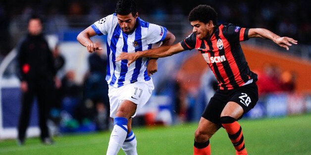 SAN SEBASTIAN, SPAIN - SEPTEMBER 17: Carlos Vela of Real Sociedad de Futbol duels for the ball with Taison of FC Shakhtar Donetsk during the UEFA Champions League Group A match between Real Sociedad de Futbol and FC Shakhtar Donetsk on September 17, 2013 in San Sebastian, Spain. (Photo by David Ramos/Getty Images)
