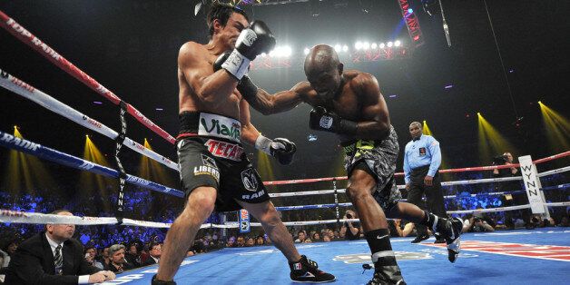 LAS VEGAS, NV - OCTOBER 12: WBO welterweight champion Timothy Bradley Jr. (R) throws a right punch at Juan Manuel Marquez during their bout at the Thomas & Mack Center on October 12, 2013 in Las Vegas, Nevada. (Photo by Jeff Bottari/Getty Images)