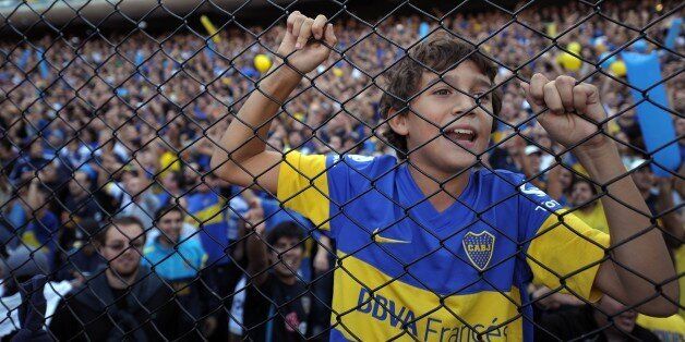 A boy, supporter of Boca Juniors, cheers his team during the Argentine First Division football match against River Plate, at the Bombonera stadium in Buenos Aires, Argentina, on May 5, 2013. AFP PHOTO / Alejandro PAGNI (Photo credit should read ALEJANDRO PAGNI/AFP/Getty Images)