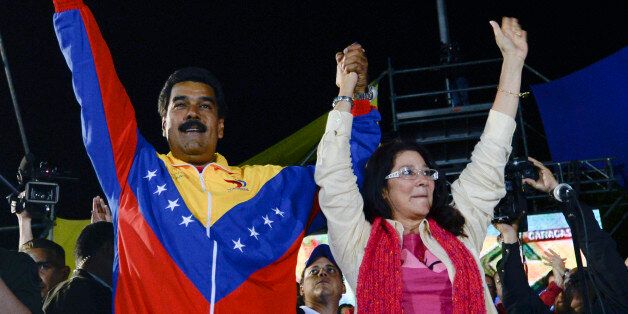 Venezuelan President elect Nicolas Maduro (L) celebrates with his wife Cilia Flores after knowing the election results in Caracas on April 14, 2013. Venezuela's acting President Nicolas Maduro declared victory on Sunday in the race to succeed late leader Hugo Chavez after the electoral council announced that he had won in a close battle. AFP PHOTO/Juan BARRETO (Photo credit should read JUAN BARRETO/AFP/Getty Images)