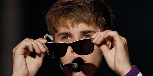 Pop sensation Justin Bieber removes his sunglasses during his "My World Tour" concert performance at Foro Sol in Mexico City, Saturday Oct. 1, 2011. (AP Photo/Marco Ugarte)