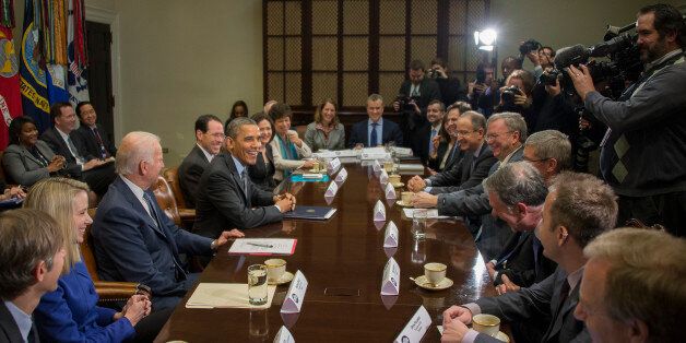 US President Barack Obama (4th L) and Vice President Joe Biden (3rd L) meet with executives from leading tech companies to discuss progress with HealthCare.gov at the White House in Washington, DC, December 17, 2013. Attending the meeting were Tim Cook, CEO, Apple; Dick Costolo, CEO, Twitter; Chad Dickerson, CEO, Etsy; Reed Hastings, Co-Founder & CEO, Netflix; Drew Houston, Founder & CEO, Dropbox; Marissa Mayer, President and CEO, Yahoo!; Burke Norton, Chief Legal Officer, Salesforce; Mark Pincus, Founder, Chief Product Officer & Chairman, Zynga; Shervin Pishevar, Co-Founder & Co-CEO, Sherpa Global; Brian Roberts, Chairman & CEO, Comcast; Erika Rottenberg, Vice President, General Counsel and Secretary, LinkedIn; Sheryl Sandberg, COO, Facebook; Eric Schmidt, Executive Chairman, Google; Brad Smith, Executive Vice President and General Counsel, Microsoft; and Randall Stephenson, Chairman & CEO, AT&T. AFP PHOTO / Jim WATSON (Photo credit should read JIM WATSON/AFP/Getty Images)