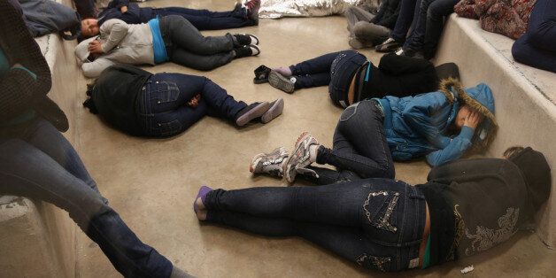 MCALLEN, TX - APRIL 11: Female undocumented immigrants sleep on the floor at the U.S. Border Patrol detainee processing center on April 11, 2013 in McAllen, Texas. According to the Border Patrol, undocumented immigrant crossings have increased more than 50 percent in Texas' Rio Grande Valley sector in the last year. With more apprehensions, they have struggled to deal with overcrowding while undocumented immigrants are processed for deportation. (Photo by John Moore/Getty Images)