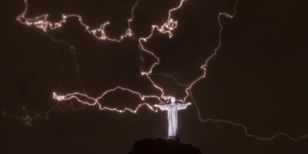 A lightning flashes over the statue of Christ the Redeemer on top of the Corcovado hill in Rio de Janeiro, Brazil, on January 16, 2014. AFP PHOTO / YASUYOSHI CHIBA (Photo credit should read YASUYOSHI CHIBA/AFP/Getty Images)