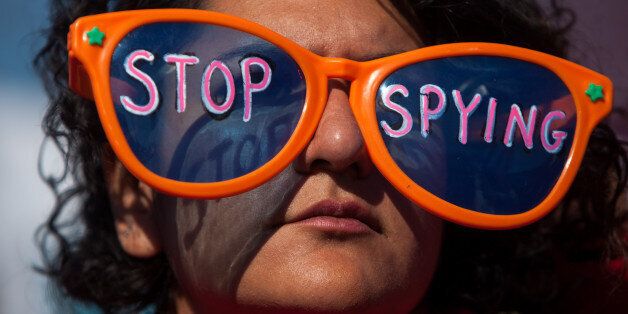 WASHINGTON, DC - OCTOBER 26, 2013: A woman wearing oversized sunglasses lettered with the words 'stop spying' listens to speakers during the Stop Watching Us Rally protesting surveillance by the U.S. National Security Agency, on October 26, 2013, in front of the U.S. Capitol building in Washington, D.C. The rally began at Union Station and included a march that ended in front of the U.S. Capitol building and speakers such as author Naomi Wolf and former senior National Security Agency senior executive Thomas Drake. (Photo by Allison Shelley/Getty Images)