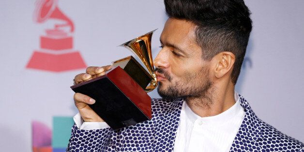 Draco Rosa poses with the award for album of the year for "Vida" backstage at the 14th Annual Latin Grammy Awards at the Mandalay Bay Hotel and Casino on Thursday, Nov. 21, 2013, in Las Vegas. (Photo by Eric Jamison/Invision/AP)