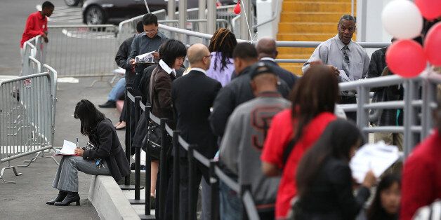 SAN FRANCISCO, CA - AUGUST 15: Job seekers fill out applications as they wait in line to enter a job fair at a new Target retail store on August 15, 2013 in San Francisco, California. Hundreds of job seekers applied for jobs during a job fair to staff a new Target City store. According to a report by the Labor Department, the number of people seeking first time unemployment benefits fell to the lowest level since 2007 with initial jobless claims decreasing by 15,000 to 320,000. (Photo by Justin Sullivan/Getty Images)