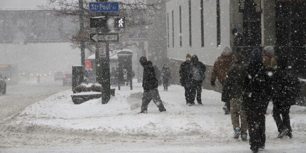 ROCHESTER, NY - FEBRUARY 5: Pedestrians walk on Main Street during a snow storm on February 5, 2014 in Rochester, New York. An additional foot of snow blanketed Western New York overnight in the latest winter storm system that has affected areas from Kansas to Maine. (Photo by Guy Solimano/Getty Images)