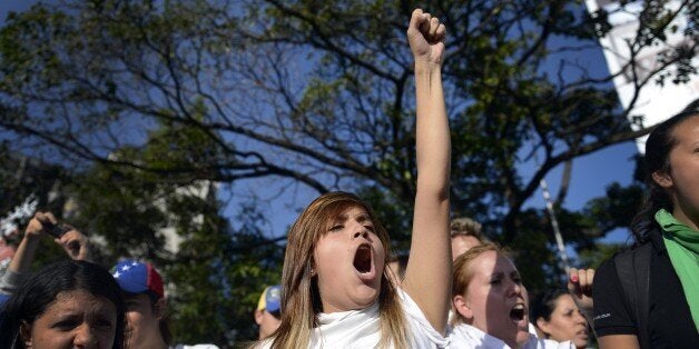 Anti-government students shout slogans during a protest in Caracas on February 16, 2014. Supporters and opponents of Venezuela's leftist government have been staging rival rallies amid spiraling discontent at the country's stubborn inflation and shortage of basic goods. Two anti-government protesters and a pro-Maduro demonstrator died in a rally last week. AFP PHOTO / LEO RAMIREZ (Photo credit should read LEO RAMIREZ/AFP/Getty Images)