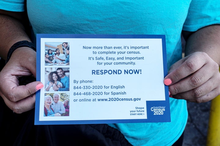 A community organizer for the nonprofit Sepa Mujer, a Latina immigrant rights group, holds a card urging people to fill out the 2020 Census form on Sept. 30, 2020 in Hampton Bays, New York. 