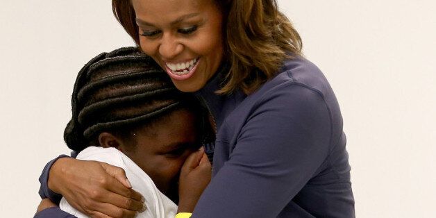 MIAMI, FL - FEBRUARY 25: First Lady Michelle Obama gives a child a hug as she arrives for a game of snag putting during a visit to the Gwen Cherry Park NFL/YET Center on February 25, 2014 in Miami, Florida. The visit was part of a celebration around the fourth anniversary of Lets Move!, her initiative to ensure that all our children grow up healthy and reach their full potential. (Photo by Joe Raedle/Getty Images)