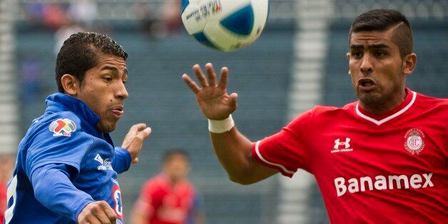 Joao Rojas (L) of Cruz Azul vies for the ball with Aaron Galindo (R) of Toluca, during their Mexican Clausura tournament in Mexico City, on March 1, 2014. AFP PHOTO/RONALDO SCHEMIDT (Photo credit should read RONALDO SCHEMIDT/AFP/Getty Images)