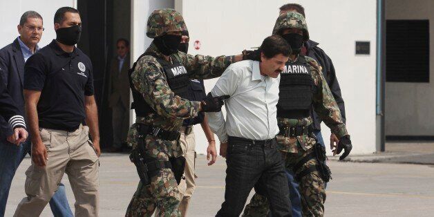 MEXICO CITY, MEXICO - FEBRUARY 22: Joaquin 'El Chapo' Guzman is escorted to a helicopter in handcuffs by Mexican navy marines at a navy hanger. Guzman leader of Mexico's Sinaloa drug Cartel, was captured alive overnight in the beach resort town of Mazatlan, considered the Mexican most-wanted drug dealer on February 22, 2014 in Mexico City, Mexico. (Photo by STR/LatinContent/Getty Images)