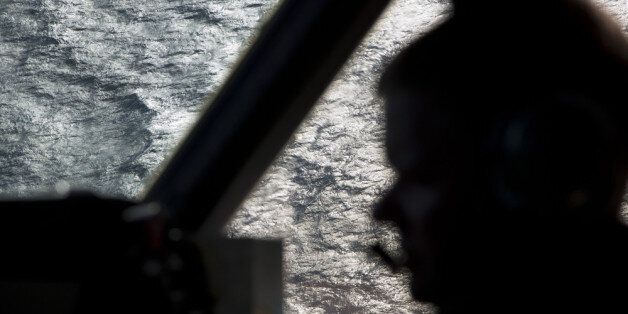 IN FLIGHT - MARCH 27: Captain Peter Moore is silhouetted against the southern Indian Ocean aboard a Royal Australian Air Force AP-3C Orion aircraft searching for missing Malaysian Airlines flight MH370, on March 27, 2014 off the coast of Perth, Australia. New images overnight have been released by a French satellite which have found 122 objects in the southern Indian Ocean which may be debris from the missing Malaysian Airlines flight MH370. Six countries have joined the search, now considered to be a recovery effort, after authorities announced that the airliner crashed in the Southern Indian Ocean and there are no survivors. (Photo by Michael Martina - Pool/Getty Images)