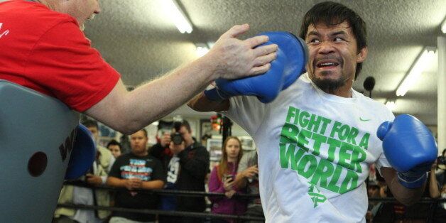 HOLLYWOOD, CA - APRIL 2: Boxer Manny Pacquiao (R) and trainer Freddie Roach (L) work the mitts during a media workout at the Wild Card Boxing Gym on April 2, 2014 in Hollywood, California (Photo by Alexis Cuarezma/Getty Images)