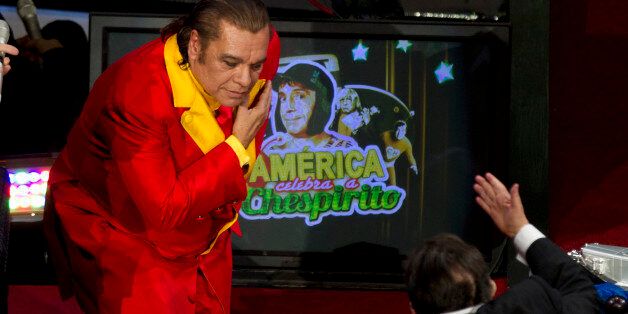 Mexican singer Juan Gabriel, left, gestures to Mexican comedian Roberto Gomez Bolanos, right, popularly known as Chespirito, on a wheelchair, during an event honoring Gomez Bolanos at the National Auditorium in Mexico City, Wednesday Feb. 29, 2012. The Chavo del Ocho show, created by Gomez Bolanos, is popular throughout Latin America and is still being aired in reruns in Mexico. (AP Photo/Eduardo Verdugo)