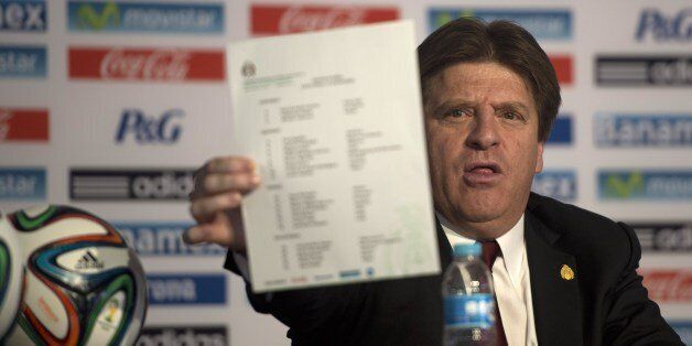 Mexico's national football team coach Miguel Herrera shows the list of footballers who will take part in the next FIFA 2014 Brazil World Cup, during a press conference in Mexico City on May 9, 2014. AFP PHOTO/ Yuri CORTEZ (Photo credit should read YURI CORTEZ/AFP/Getty Images)