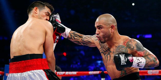 NEW YORK, NY - JUNE 07: Miguel Cotto of Puerto Rico (R) lands a right punch to the face of Sergio Martinez of Argentina during the first round as they battle for the WBC Middleweight Championship on June 7, 2014 at Madison Square Garden in New York City. Cotto won by a TKO in the ninth round. (Photo by Rich Schultz/Getty Images)
