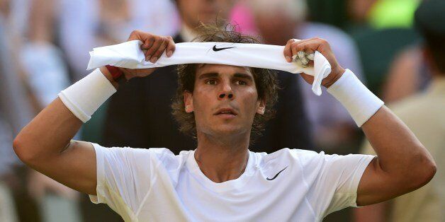 Spain's Rafael Nadal adjusts his headband between sets during his men's singles fourth round match against Australia's Nick Kyrgios on day eight of the 2014 Wimbledon Championships at The All England Tennis Club in Wimbledon, southwest London, on July 1, 2014. AFP PHOTO / CARL COURT - RESTRICTED TO EDITORIAL USE (Photo credit should read CARL COURT/AFP/Getty Images)