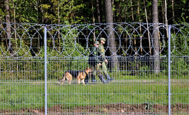 Des gardes-frontières biélorusses patrouillent à la frontière entre la Lituanie et la Biélorussie, à Salcininkai, en Lituanie, le 27 mai 2021. (Photo by PETRAS MALUKAS/AFP via Getty Images)