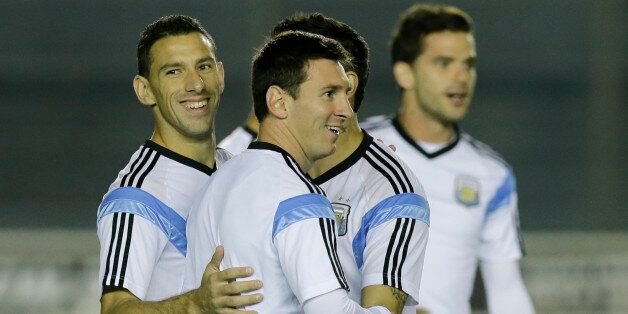 Argentina's Lionel Messi, center, Maxi Rodriguez, left, and Fernando Gago, right, take part in an official training session at Vasco da Gama Stadium a day before the World Cup soccer final between Germany and Argentina in Rio de Janeiro, Brazil, Saturday, July 12, 2014. (AP Photo/Victor R. Caivano)