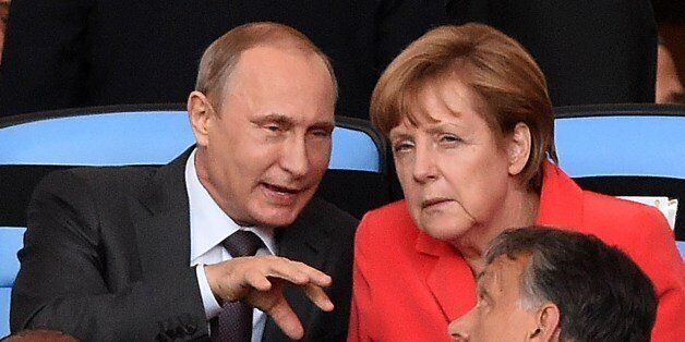 German Chancellor Angela Merkel (R) and Russian President Vladimir Putin chat during the second half of the 2014 FIFA World Cup final football match between Germany and Argentina at the Maracana Stadium in Rio de Janeiro on July 13, 2014. AFP PHOTO / PEDRO UGARTE (Photo credit should read PEDRO UGARTE/AFP/Getty Images)