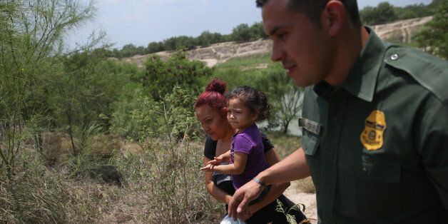 MISSION, TX - JULY 24: A mother and child, 3, from El Salvador are escorted by a U.S. Border Patrol Agent after they crossed the Rio Grande into the United States on July 24, 2014 in Mission, Texas. Tens of thousands of immigrant families and unaccompanied minors have crossed illegally into the United States this year and presented themselves to federal agents, causing a humanitarian crisis on the U.S.-Mexico border. (Photo by John Moore/Getty Images)