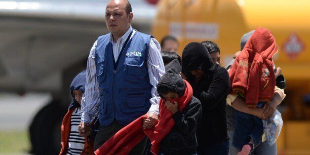 Part of a group of thirteen children, aged between one and 13, and seven mothers walk upon arrival in Guatemala deported from the United States amidst the humanitarian crisis caused by Central American immigrant children, at the Air Force Base in Guatemala City on July 22, 2014. US authorities have detained some 57,000 unaccompanied minors since last October, twice the number from the same period a year ago, seeking to illegally cross into the US from Mexico. Three quarters of the minors are from El Salvador, Guatemala and Honduras. AFP PHOTO / Johan ORDONEZ (Photo credit should read JOHAN ORDONEZ/AFP/Getty Images)