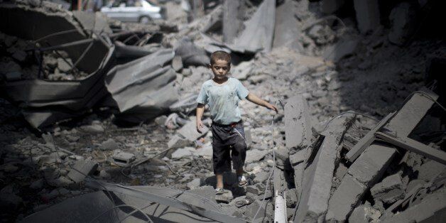 A Palestinian boy makes his way through the rubble of a house after it was destroyed by an Israeli military strike in the Jabalia refugee camp, in the northern Gaza Strip, on August 9, 2014. Israeli warplanes pounded targets in Gaza, a day after killing at least five Palestinians, and militants fired dozens of rockets into Israel after attempts to extend a three-day truce stalled. AFP PHOTO / MAHMUD HAMS (Photo credit should read MAHMUD HAMS/AFP/Getty Images)