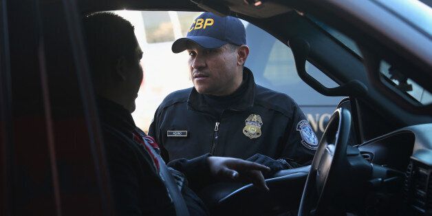 NOGALES, AZ - FEBRUARY 26: An Customs and Border Protection officer from the U.S. Office of Field Operations (OFO), speaks with a motorist crossing from Mexico into the United States on February 26, 2013 in Nogales, Arizona. Some 15,000 people cross between Mexico and the U.S. each day in Nogales, Arizona's busiest border crossing. (Photo by John Moore/Getty Images)
