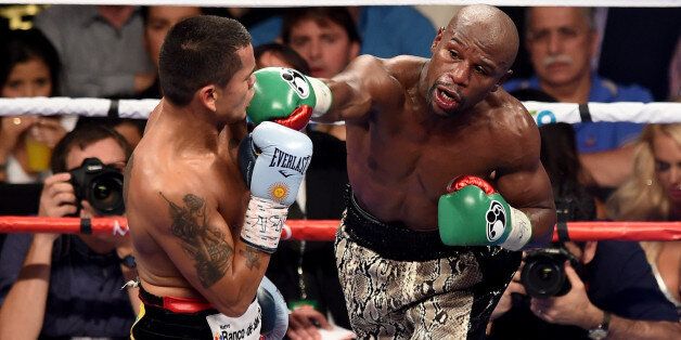 LAS VEGAS, NV - SEPTEMBER 13: (R-L) Floyd Mayweather Jr. throws a right to the face of Marcos Maidana during their WBC/WBA welterweight title fight at the MGM Grand Garden Arena on September 13, 2014 in Las Vegas, Nevada. (Photo by Ethan Miller/Getty Images)