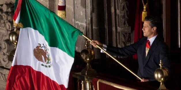 MEXICO CITY, MEXICO - SEPTEMBER 15: Mexico's President Enrique PeÂÃ±a Nieto waves a nation's flag after giving the traditional 'El Grito,' or shout during the anniversary of the 'Grito de Dolores,' honoring the call to arms made by the priest Miguel Hidalgo in 1810 that began the struggle for independence from Spain, achieved in 1821, on September 07, 2013 in Mexico City, Mexico. (Photo by Miguel Tovar/LatinContent/Getty Images)