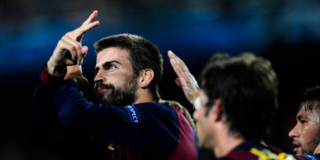 Barcelona's Gerard Pique, left, celebrates scoring against APOEL during the Champions League Group F soccer match between Barcelona and Apoel at the Camp Nou stadium in Barcelona, Spain, Wednesday, Sept. 17, 2014. (AP Photo/Manu Fernandez)