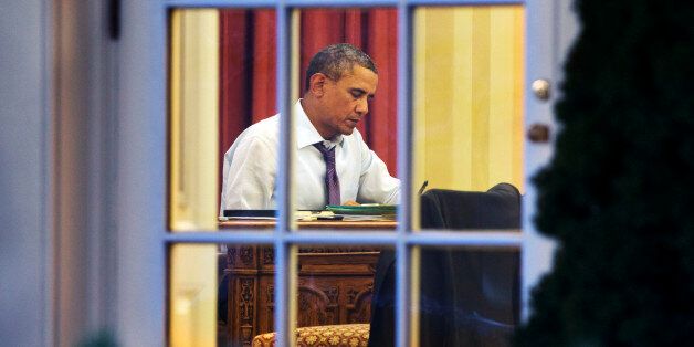 President Barack Obama works at his desk in the Oval Office of the White House in Washington, Monday, Jan. 27, 2014, ahead of Tuesday night's State of the Union speech. (AP Photo/Jacquelyn Martin)