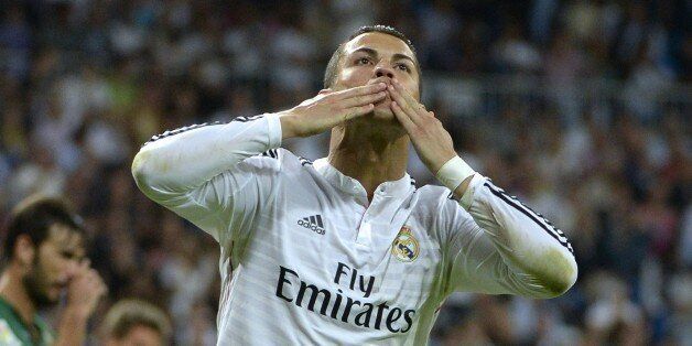 Real Madrid's Portuguese forward Cristiano Ronaldo celebrates after scoring his third goal during the Spanish league football match Real Madrid CF vs Elche CF at the Santiago Bernabeu stadium in Madrid on September 23, 2014. AFP PHOTO / GERARD JULIEN (Photo credit should read GERARD JULIEN/AFP/Getty Images)