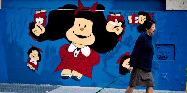 A woman walks her dog in front of a Children's hospital with a mural of Mafalda, the main character of the comic strip by Argentine cartoonist Joaquin Salvador Lavado, better known as Quino, in Buenos Aires, Argentina, Wednesday, April 23, 2014. The comic strip, about a sharp tongued 6 year old, celebrates its 50th anniversary this year. Mafalda became Argentinaâs most famous comic strip character, particularly renowned for her political satire. Quino will inaugurate the Buenos Aires 2014 Book Fair Thursday. (AP Photo/Natacha Pisarenko)