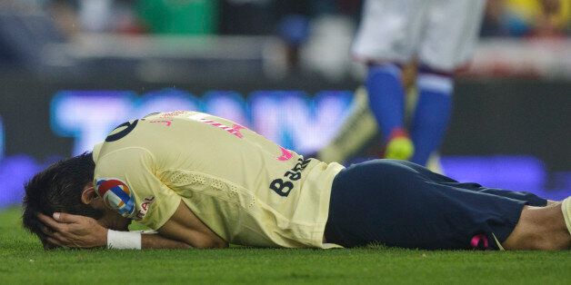 America's Jesus Molina reacts after missing a chance to score against Cruz Azul during a Mexican soccer league match in Mexico City, Saturday, Oct. 4, 2014. (AP Photo/Christian Palma)