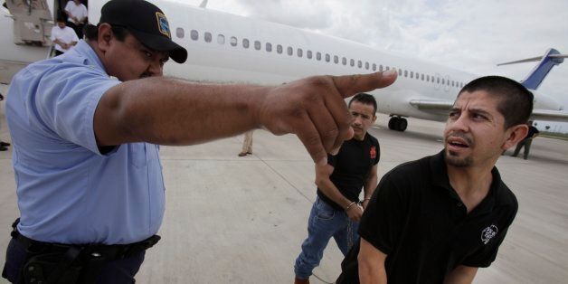In this May 25, 2010 photo, shackled Mexican immigrants are directed by a guard to a waiting deportation by the U.S. Immigration and Customs Enforcement in Harlingen, Texas. In the last year, more than 350,000 illegal immigrants have been deported _ about 220,000 by plane. The number of immigrants sent back to their homelands has more than tripled in the last decade and is expected to continue soaring. (AP Photo/LM Otero)
