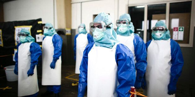 Volunteers of the German forces Bundeswehr line up for a decontamination of their protective suits during a training for the Ebola virus in Appen about 25 kilometers (15,5 miles) north of Hamburg, Germany, Thursday, Oct. 23, 2014. The volunteers of the German forces Bundeswehr get trained for a mission to support the German Red Cross in Liberia in the fight against the Ebola epidemic. (AP Photo/Markus Schreiber)