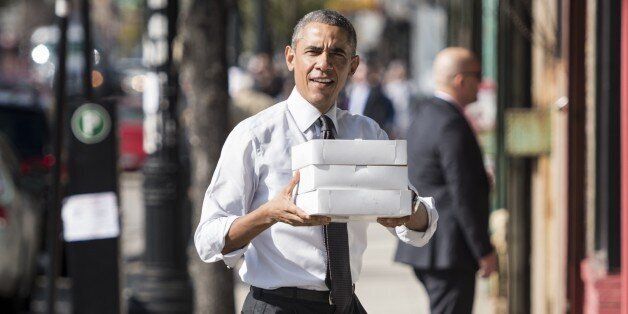 US President Barack Obama brings doughnuts and pastries to Democratic campaign volunteers October 20, 2014 in Chicago, Illinois. President Barack Obama cast his ballot Monday during a visit in his hometown of Chicago two weeks ahead of November 4 mid-term elections. 'I love voting. Everybody in Illinois, early vote. It's a wonderful opportunity,' Obama said after submitting his vote at the Martin Luther King Jr Park & Family Entertainment Center. AFP PHOTO/Brendan SMIALOWSKI (Photo credit should read BRENDAN SMIALOWSKI/AFP/Getty Images)