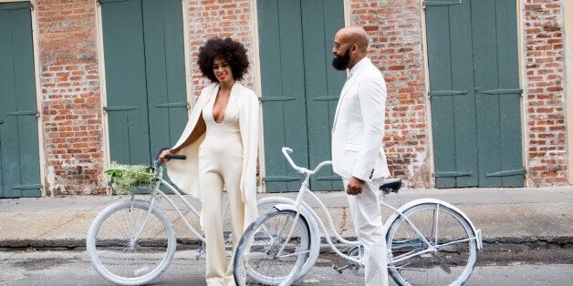 NEW ORLEANS, LA - NOVEMBER 16: Musician Solange Knowles (wearing a pre-ceremony ensemble by Stephane Rolland) and her fiance, music video director Alan Ferguson, ride bicycles on the streets of the French Quarter en route to their wedding ceremony at the Marigny Opera House on November 16, 2014 in New Orleans, Louisiana. (Photo by Josh Brastead/WireImage)