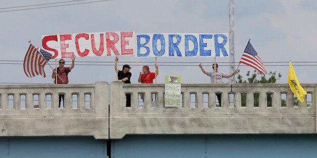 Demonstrators hold signs from an overpass during a protest against people who immigrate illegally on Friday, July 18, 2014, in Indianapolis. What was once a debate over how to fix a broken immigration system and provide a path to citizenship for millions has now become a race to decide how to boost border patrols and send immigrants quickly back to their countries of origin. (AP Photo/Darron Cummings)
