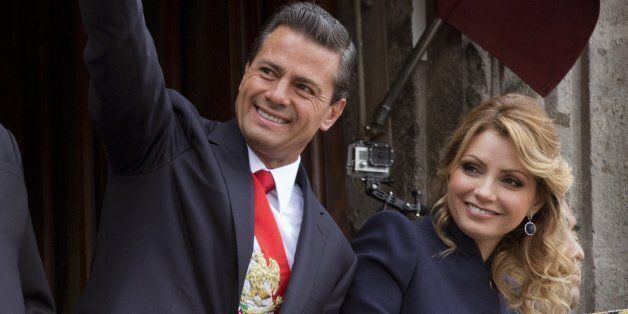 Mexico's President Enrique Pena Nieto waves as he stands with his wife Angelica Rivera while overseeing Independence Day celebrations from the balcony of the National Palace, in central Mexico City, Tuesday, Sept. 16, 2014. Mexico is marking the 204th anniversary of its independence from Spain. (AP Photo/Rebecca Blackwell)