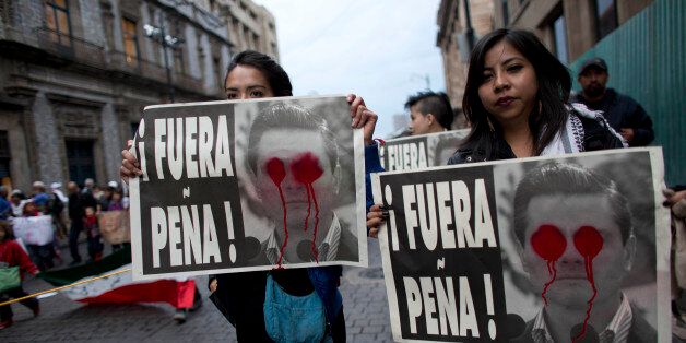 Protesters hold up posters that read in Spanish "Pena Out!" demanding the removal of Mexico's President Enrique Pena Nieto during a massive march to pressure the government into finding 43 missing college students, in Mexico City,Thursday, Nov. 20, 2014. Mexico officially lists more than 22 thousand people as having gone missing since the start of the country's drug war in 2006, and the search for the missing students has turned up other, unrelated mass graves. (AP Photo/Rebecca Blackwell)