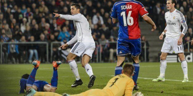 Real Madrid's Portuguese forward Cristiano Ronaldo (L) gestures next to teammate Welsh forward Gareth Bale (R) after scoring his team's first goal on November 26, 2014 during a UEFA Champions League Group B football match between FC Basel and Real Madrid in Basel. AFP PHOTO / FABRICE COFFRINI (Photo credit should read FABRICE COFFRINI/AFP/Getty Images)