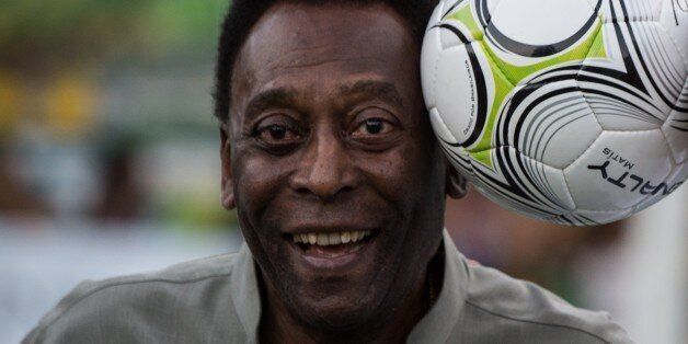 Legendary Brazilian former football player Pele poses with a ball during the inauguration ceremony of the new technology football pitch installed at Mineira favela in Rio de Janeiro, Brazil, on September 10, 2014. 200 self energy supplied Pavegen panels, invented by British Laurence Kemball-Cook, were installed underground to capture kinetic energy created by the movement of the football players. The energy is stored and combined with solar panels' energy to illuminate the pitch during the night. The new technology pitch was created by oil giant Royal Dutch Shell. AFP PHOTO / YASUYOSHI CHIBA (Photo credit should read YASUYOSHI CHIBA/AFP/Getty Images)