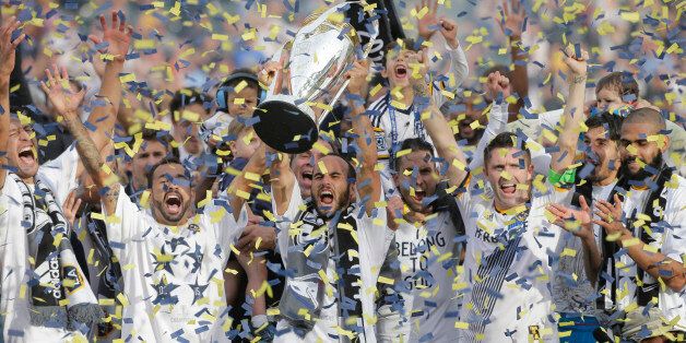 Los Angeles Galaxy's Landon Donovan, center, hoists the trophy as he and teammates celebrate after winning the MLS Cup championship soccer match against the New England Revolution Sunday, Dec. 7, 2014, in Carson, Calif. (AP Photo/Jae C. Hong)